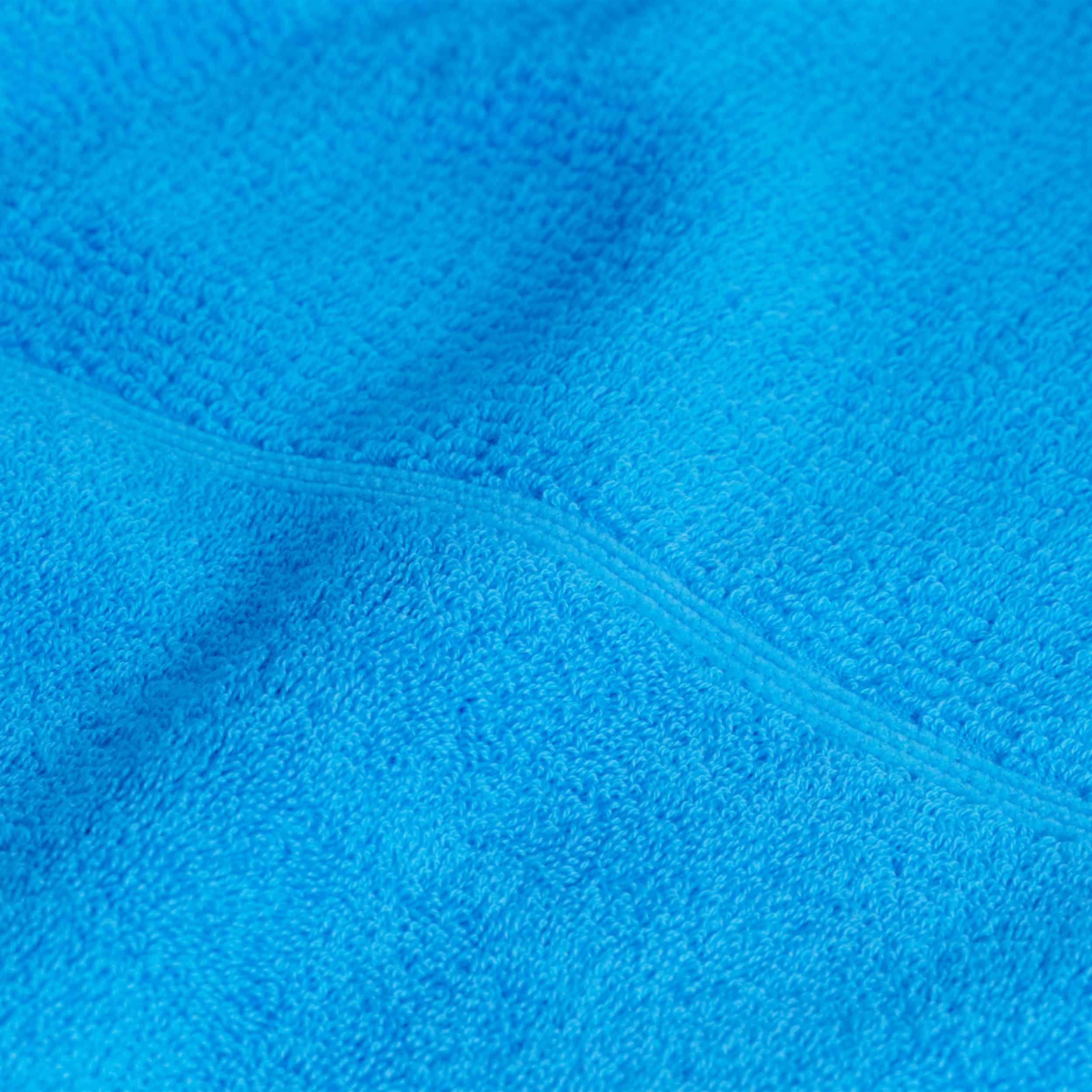 Handtuch — leuchtend blaues Frottee liegt flach; Detailaufnahme zeigt Schlingenstruktur und Naht, typisch für ein Badezimmertextil.